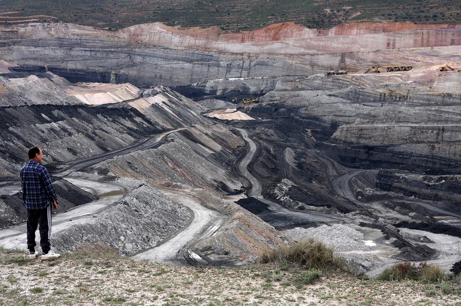 Photo of the incredible scale of a coal mine in Estercuel, Spain, emphasised by an onlooker and the tiny (but in reality enormous) machinery in the background.